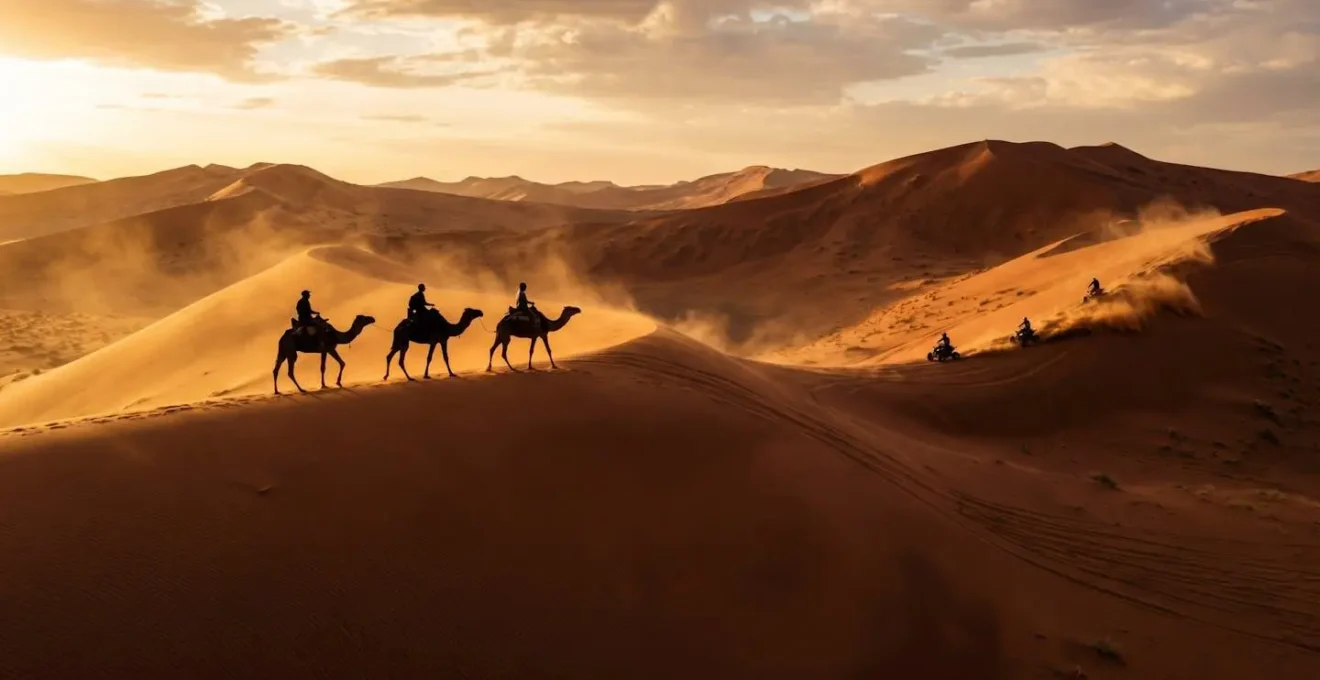 Camel riders crossing sand dunes at sunset during Khawa Cultural Festival